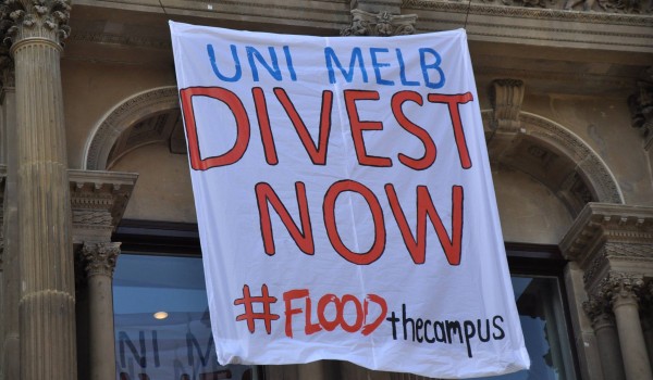 Banner hanging from the University's MSD building with the words "UniMelb Divest Now #FLOODthecampus"